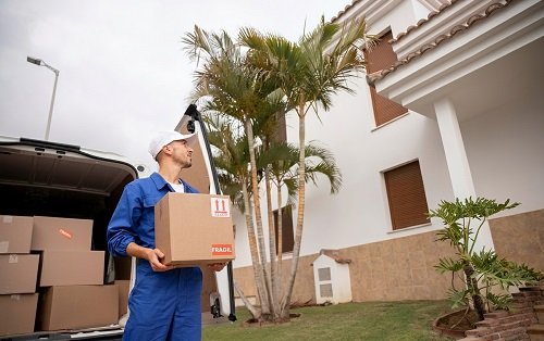 Movers loading house shifting boxes into a truck